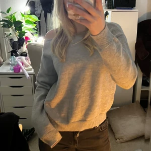 Grå offshoulder tröja - Säljer en stilren helt oanvänd grå offshoulder tröja med långa ärmar. Perfekt för en avslappnad look. Tröjan har ribbade muddar vid ärmslut och nederkant. Jättemjuk och skön🩷