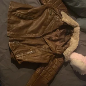 Brun skinnjacka med foder - Snygg brun skinnjacka med ett lite slitning där bak i nacken men inget man ser pågrund av pälsen som lägger sig över det 