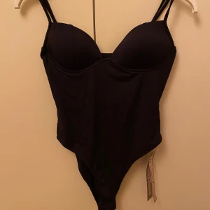 Svart body från Missguided - Snygg svart body från Missguided med dubbla axelband och en stilren design. Tillverkad i ett bekvämt material som ger en bra passform. Helt oanvänd