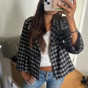 Trekvarts jacka - Snygg rutig kavaj i svart och grått med trekvartsärmar. Perfekt för en stilren look. Kavajen har en klassisk passform och är lätt att matcha med olika outfits.