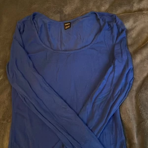 Blå långärmad topp från Shein - Säljer en stilren blå långärmad topp från Shein i storlek Petite XXS. Perfekt för en enkel och bekväm look. Tillverkad i ett mjukt material som känns skönt mot huden.