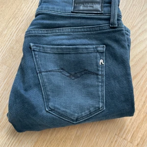 Grå  jeans från Replay - Snygga blå jeans från Replay med klassisk femficksdesign. De har en normal passform och är perfekta för en avslappnad stil. Märkeslogga på bakfickan ger en extra touch.