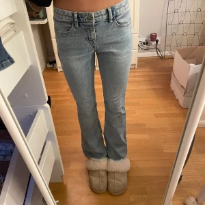Ljusblå bootcut jeans - Snygga ljusblå bootcut jeans med klassisk femficksdesign. De har en lågmidjad passform och är perfekta för en avslappnad stil. Jeansen har en dragkedja och knapp framtill.