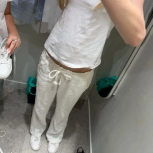 Vita linnebyxor med snörning - Snygga och bekväma vita linnebyxor med snörning i midjan. Perfekta för en avslappnad stil. Byxorna har en loose passform och är tillverkade i ett lätt och luftigt material.