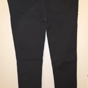 Svarta jeans från Tommy Jeans - Snygga svarta jeans från Tommy Jeans i storlek L. De har en klassisk design med raka ben och två bakfickor. Perfekta för en stilren look.