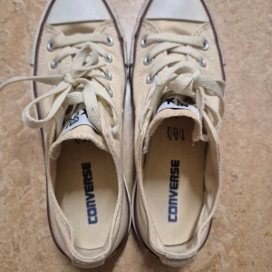 Beige Converse skor - Säljer ett par klassiska beige Converse sneakers med snörning. Används inte längre, fortfarande mycket bra skick! 