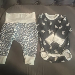 Mörkblå body med kaninmönster och matchande byxor - Säljer en söt mörkblå body med vita kaniner och matchande byxor med blått och vitt mönster från Bebe. Bodyn har långa ärmar och praktiska knappar i grenen för enkel påklädning. Perfekt för de minsta, storlek 60 CL (2-4 månader).