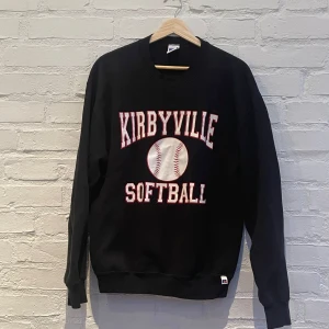 Svart sweatshirt från Russell Athletic - Säljer en svart sweatshirt från Russell Athletic med texten 'Kirbyville Softball' och en stor baseball på framsidan. Tröjan har långa ärmar och en klassisk rund halsringning. Perfekt för sportiga tillfällen eller en avslappnad stil.