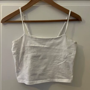 Vit linnetopp - Säljer en enkel och stilren vit linnetopp med smala axelband. Perfekt för varma sommardagar eller som ett basplagg i garderoben.Storlek S