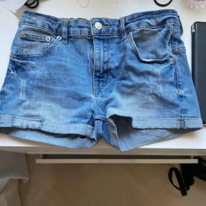 Blå jeansshorts - Snygga blå jeansshorts med klassisk femficksdesign och knappgylf. Perfekta för en avslappnad stil. De har en lätt tvättad look och är bekväma att bära.