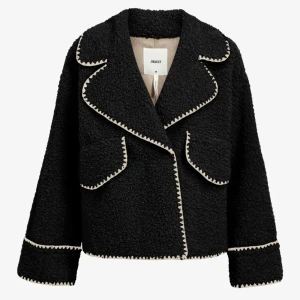 Svart teddyjacka från Object - Snygg svart teddyjacka från Object med kontrasterande vita sömmar. Jackan har en oversized passform och långa ärmar. Mycket bra skick, aldrig använd. Prislappen sitter kvar.