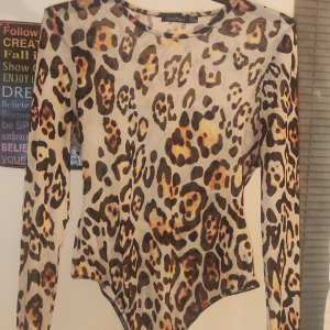 Leopardmönstrad långärmad body från Boohoo - Snygg leopardmönstrad långärmad body från Boohoo. Perfekt för att ge din outfit en djärv touch. 30 Tillverkad i ett lätt och bekvämt material.