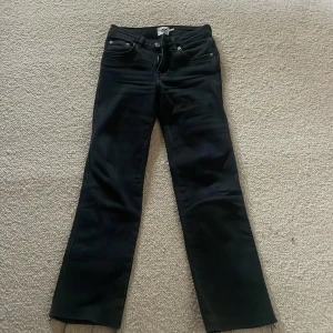 Svarta bootcut jeans  - Snygga svarta bootcut jeans med klassisk femficksdesign och knappgylf. Perfekta för en stilren look. Passar till många olika outfits.