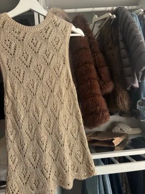 Guldig stickad topp - Säljer en guldig stickad topp med snyggt hålmönster och ribbad halsringning. 