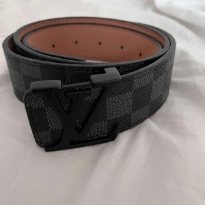 L-bälte  - Snyggt L-bälte i Damier-mönster med svart spänne.  Storlek: 110 cm