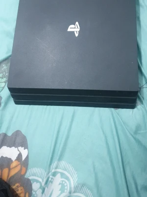 PlayStation 4 Pro svart konsol - Lite Högljud utan handkontroll Säljer en svart PlayStation 4 Pro från Sony. Konsolen har den klassiska fyrkantiga designen med tre lager och PlayStation-loggan i silver på ovansidan. Tillverkad i matt plast och passar perfekt för gaming och streaming.