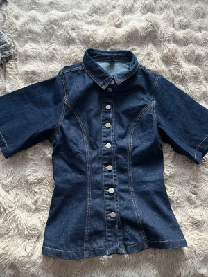 Jeansskjorta  - Jättesnygg jeansskjorta med figurnära passform. Skjortan är mörkblà och har normallängd. Helt nytt. Prislappen har avlägsnats. Köpte för 499🤍
