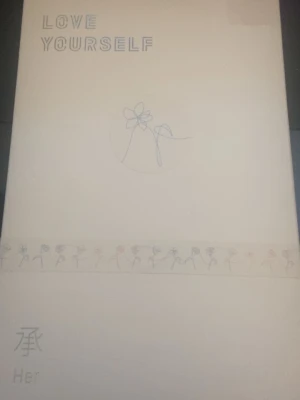 Love Yourself Her album - Love Yourself Her är en stilren album-bok med vit framsida, minimalistisk blomillustration och text i pastellfärger. Boken är utgiven av HYBE och har detaljer på koreanska och engelska. Perfekt för dig som gillar K-pop och snygg design. Original pris 319