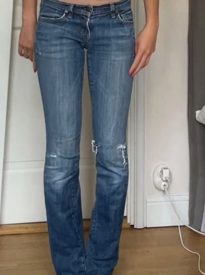 Blå low waist jeans med hål  - Snygga blå jeans med låg midja och hål. Osäker på märket men modellen heter ava #142. Skriv om du har frågor!! 