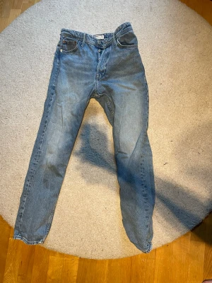 Blå loose fit jeans från Jack & Jones - Säljer ett par blå loose fit jeans från Jack & Jones, modell Chris. Jeansen har klassisk femficksdesign, raka ben och knappgylf. Tillverkade i slitstark denim med en ljus tvätt som ger en avslappnad look.