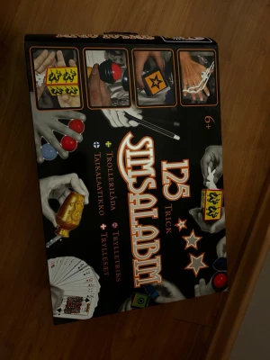 Trollerilåda SimsalaBim 125 trick - Säljer en trollerilåda från SimsalaBim med 125 olika trick. Innehåller magiska tillbehör som trollstav, kortlek, bollar, ringar, rep och figurer i plast. Perfekt för dig som vill lära dig coola trolleritrick och imponera på vännerna.