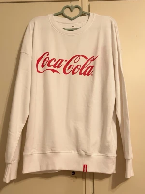 Ny vit coca cola tröja - Oanvänd och ny vit coca cola tröja. Vet tyvärr inte vad den kostade som ny.
