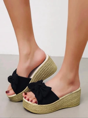 Svarta platåsandaler med rosett - Snygga svarta sandaler med breda band och stora rosetter framtill. Sandalerna har en hög platåsula i flätad jute-look som ger en somrig känsla. Perfekta för dig som vill ha både höjd och stil. Öppen tå och slip-in modell. Fotlängd: 24,5 cm. Storlek 40😊 knappt använda🥰