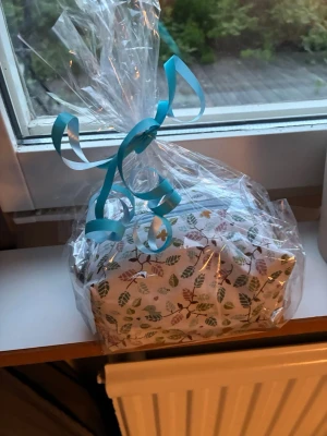 Necessär med lövmönster och dragkedja - Söt necessär med vitt tyg och färgglatt lövmönster i grönt, brunt och rosa. Säljer då jag vann den men inte vill ha den. Handgjord och helt oöppnad och oanvänd 