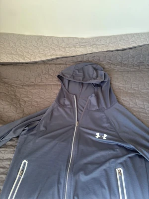 Mörk blå vindjacka från Under Armour - En mörk blå aktig under armour kofta / vindjacka i storlek M men passar S använt kanske 2 gånger. Den är lite kortare än vanlig M vilket motsvarar mer mot S 