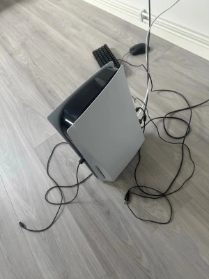 PlayStation 5 spelkonsol - Säljer en PlayStation 5 från Sony. Konsolen har en futuristisk design med vita och svarta paneler i plast och en slimmad, kurvig form. Perfekt för dig som vill spela de senaste spelen med grym prestanda och snygg grafik.