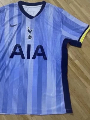Tottenham Hotspur matchtröja Nike - Snygg ljusblå Tottenham Hotspur matchtröja från Nike med mörkblå detaljer och gula inslag vid ärmslut. Tröjan har klubbens emblem och sponsorlogga på bröstet samt korta ärmar. Perfekt för fotbollsträning eller att bära på läktaren.