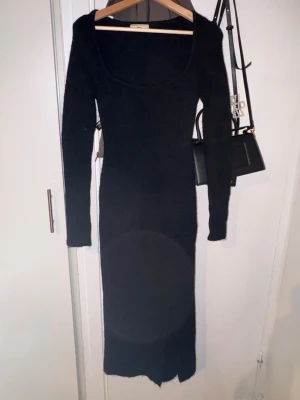 Svart lång stickad klänning Gina Tricot - Lång svart stickad klänning från Gina Tricot med rundad halsringning och långa ärmar. Klänningen har en figurnära passform och är perfekt för dig som gillar en stilren och enkel look.