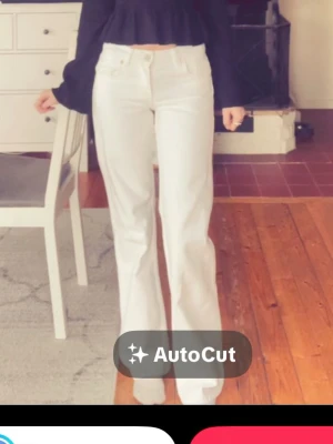Vita raka jeans med hög midja - Snygga vita jeans med rak passform och hög midja. Klassisk femficksmodell med knapp- och dragkedjegylf. Perfekta att styla med crop top eller stickad tröja. Materialet ser ut att vara bomull eller bomullsblandning.