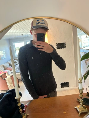 Polo Ralph Lauren - Mörkgrå långärmad tröja från Polo Ralph Lauren. Tröjan har en snygg krage med knappar vilket gör att den även funkar för lite mer uppklädda tillfällen. Här gärna av er vid frågor!
