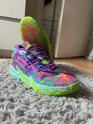 Puma MB.03 Be you sneakers! - Detta är ett par Puma MB.03 Be You sneakers.  Det är ett par Lamelo Ball alltså ett par basketskor/inneskor. De är i ett jättebra skick bara använt några gånger. Storlek 42, ny pris ca 1500kr. Bud från 400kr