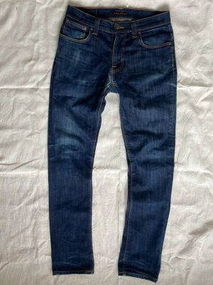 Mörkblåa Nudie jeans | 32  - Sjukt snygga mörkblå jeans från Nudie med snygga slitningar | Skick: Mycket bra | Strl: W32 L34 | Modellen är 175 cm och väger 65 kg | Hör av dig vid funderingar ⁉️