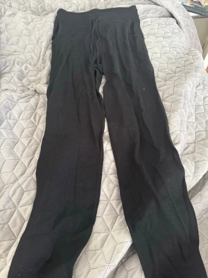 Svarta ribbade leggings - Svarta leggings med ribbad struktur och hög midja. Mjukt och stretchigt material som sitter skönt på kroppen. Perfekta att matcha med oversized tröjor eller hoodies. Klassisk modell utan synliga loggor eller detaljer.