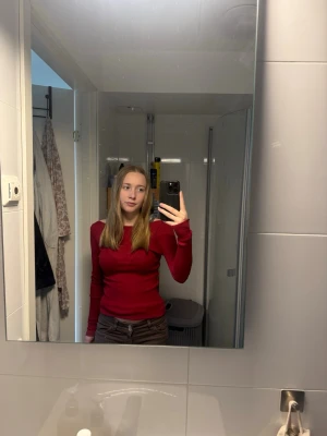 Röd långärmad topp från intimissimi - Snygg röd långärmad topp med figurnära passform. Enkel och stilren design, perfekt att matcha med olika outfits. Mjuk och stretchig känsla, passar dig som gillar en tight look.