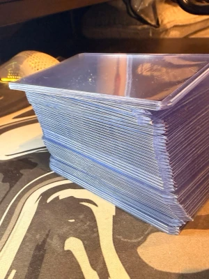 Protektor för kort och hållare - Säljer ett rejält paket med blåa plast sleeves för samlarkort. Perfekt för att skydda dina Pokémon-, Magic- eller andra spelkort. Sleevesen är genomskinliga på ena sidan och blåa på baksidan. Passar standardstorlek på kort.