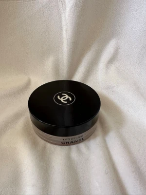 Chanel Les Beiges Bronzer - Chanel Les Beiges Bronzer i en rund burk med svart lock och ikonisk logga. Krämig formula i en varm, naturlig brun nyans som ger en solkysst look. Perfekt för att skulptera och framhäva ansiktet. Lyxig förpackning. Säljer då färgen inte passade min hudton🤍