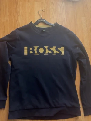 Blå sweatshirt från Hugo Boss - Gör dig redo för hösten redan nu!  Säljer nu min Hugo boss sweatshirt (blå) i storlek M. Köpt i mall of Scandinavia I hugo boss butiken.  Anledning? Använder den inte längre  Skick? Mycket bra skulle jag säga, använt den lite mer i yngre dagar men nu hänger den bara i garderoben.  Pris? 300  Frågor eller nyfiken? Hör av dig!