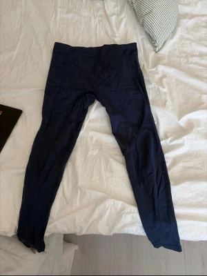 Mörkblå tights från Relode - Mörkblå tights från Relode med hög midja och stretchigt material. Tightsen har en stilren design utan fickor och loggan är placerad baktill i midjan. Perfekta för träning och sport.
