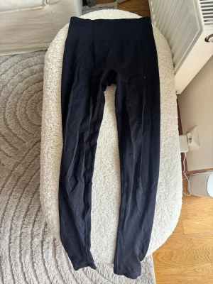 Svarta leggings Prime Scrunch Relode - Säljer ett par svarta leggings med hög midja och stretchigt material. De har en enkel, klassisk design utan synliga loggor eller detaljer. Perfekta till oversized tröjor eller hoodies. Passar dig som gillar bekväma och stilrena plagg.