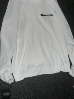 Vit långärmad topp Sail Racing - Vit långärmad topp från Sail Racing med rund halsringning och diskret logga på bröstet. Tillverkad i mjukt material som känns skönt mot huden. Perfekt för en clean och stilren look.