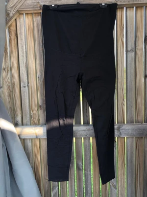 Svarta höga leggings - Säljer ett par svarta leggings med hög midja och smal passform. De är stretchiga och mjuka, perfekta för en avslappnad look. Materialet känns som bomull eller en bomullsblandning. Passar till allt och är superenkla att styla.
