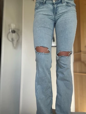 Ljusblå jeans nelly - Säljer ett par jätte snygga ljusblå bootcut jeans med hål i knäna från nelly storlek 36. Bra skick skriv om ni har några frågor💕
