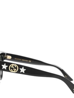 Svarta Gucci solglasögon med stjärnor - Snygga svarta solglasögon från Gucci med breda skalmar dekorerade med guldfärgade GG-loggor och silverfärgade stjärnor. Glasögonen har en klassisk, fyrkantig form och är tillverkade i blank plast. Perfekta för dig som vill sticka ut med en lyxig accessoar.