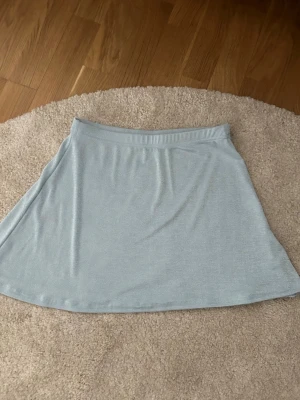Ljusblå kortkjol från Missguided - Snygg ljusblå kortkjol från Missguided i ett mjukt och stretchigt material. Kjolen har en enkel och clean design med resår i midjan och lätt utställd passform. Perfekt att matcha med en crop top eller hoodie.
