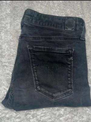 Replay jeans  - Svarta Repaly Hyperflex Jeans. Midja 35cm, längd 99cm. JAG SKICKAR EJ FLER BILDER NÄR JAG BÄR JEANSEN! för bättre inblick i passformen rekommenderar jag att googla på modellnamnet. För storleksguide kolla måtten noggrant då jeansen alltid kan vara uppsydda heller krympta och jag ej tar emot returer :) 