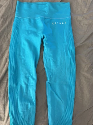 Turkosa seamless leggings från Relode - Snygga turkosa seamless leggings från Relode med hög midja och ribbade detaljer längs sidorna och midjan. Stretchigt material som sitter skönt och formar sig efter kroppen. Perfekta för träning eller chill dagar.